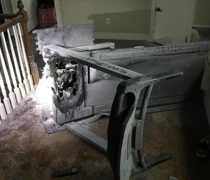 Burned and charred treadmill covered in soot and fire extinguisher dust
