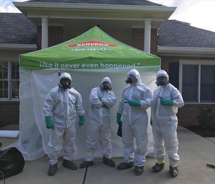 SERVPRO workers in Tyvek suits outside a containment for Coronavirus disinfection.